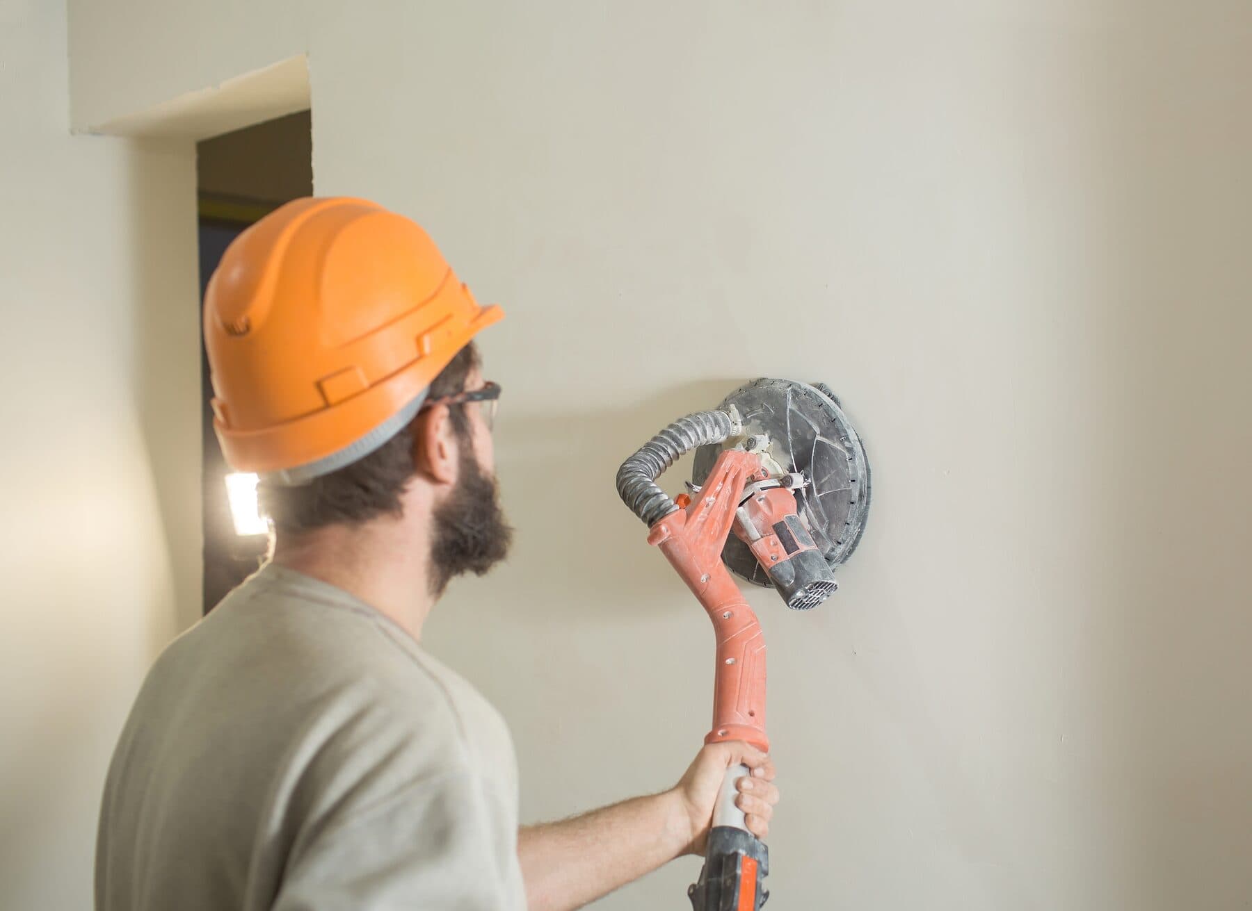 Graceful Interiors crew member sanding a freshly finished wall